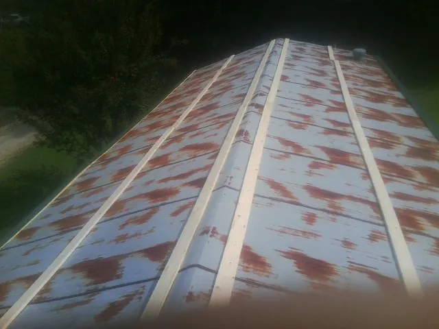 Rusted metal roof panels with new wood purlins before replacement — Storm Damage Roof Repair in Alcove by Roofing Brothers