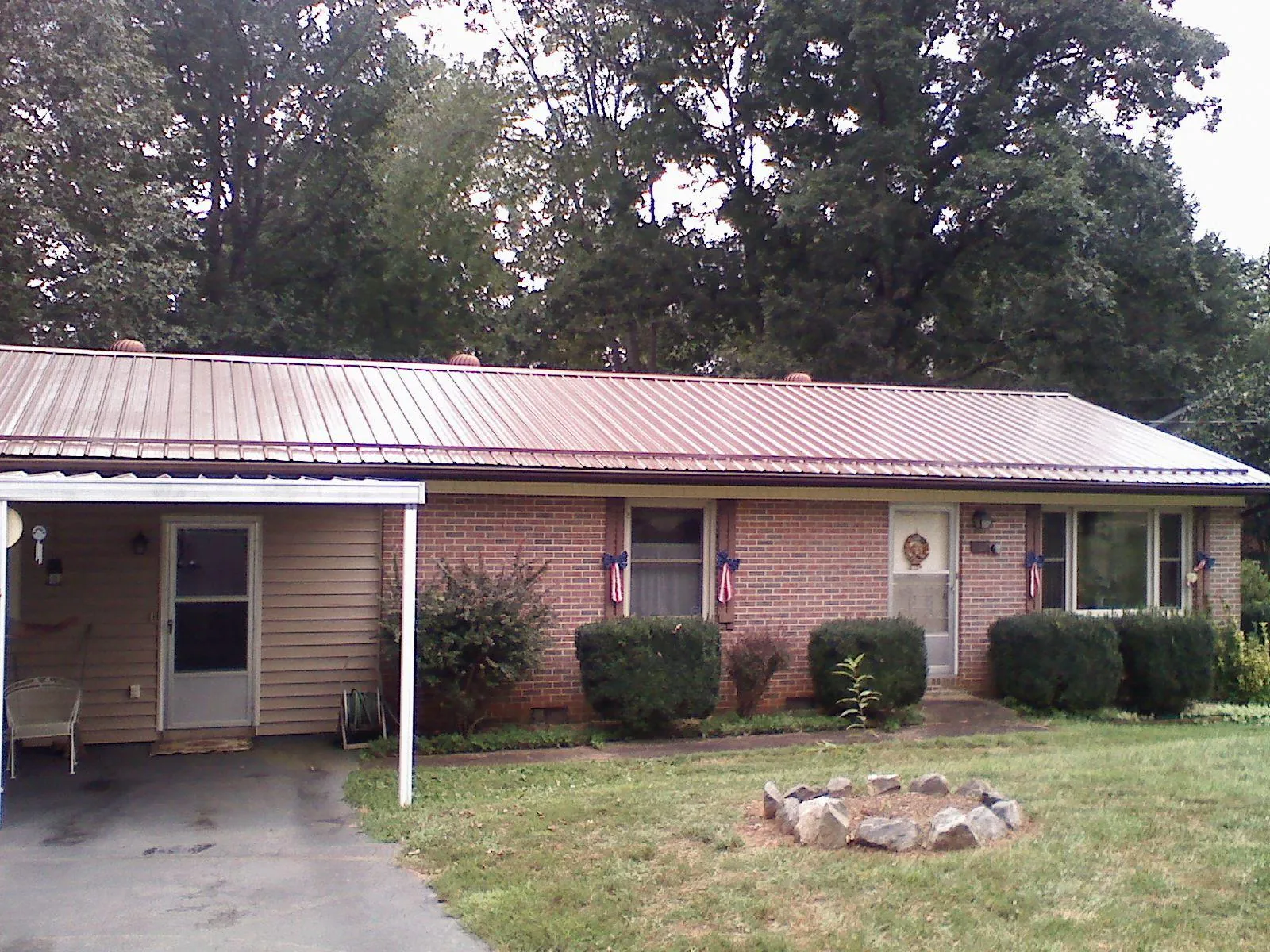 Bronze metal roof and carport on a brick ranch home — Roof Repair work by our crew in Alcove